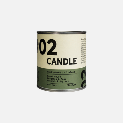 A paint pot style candle tin measuring 7.5cm x 7.5cm, with a lever lid on top and a wrap around paper label containing graphics that say 01 Candle, hand poured in Ireland, bergamot & musk.