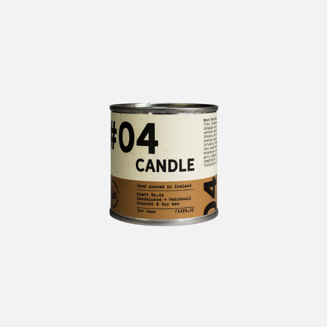 A paint pot style candle tin measuring 5.5cm x 5.5cm, with a lever lid on top and a wrap around paper label containing graphics that say 01 Candle, hand poured in Ireland, sandalwood & patchouli.