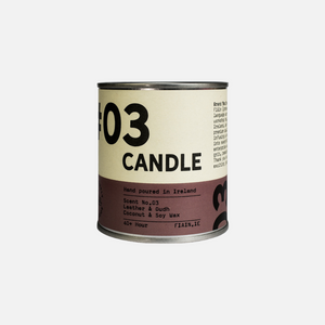 A paint pot style candle tin measuring 7.5cm x 7.5cm, with a lever lid on top and a wrap around paper label containing graphics that say 01 Candle, hand poured in Ireland, leather & Oudh.